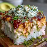 Freshly baked Spicy Salmon Sushi Bake with creamy rice, spicy salmon, and melted cheese, ready to scoop with nori.