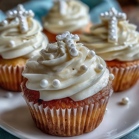 Sweet buttercream-frosted mini cupcakes adorned with edible fondant rosary toppers, perfect for religious milestone gatherings.