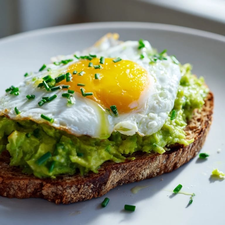 Vibrant green avocado mash on crispy whole-grain toast, garnished with cilantro and a pinch of sea salt.