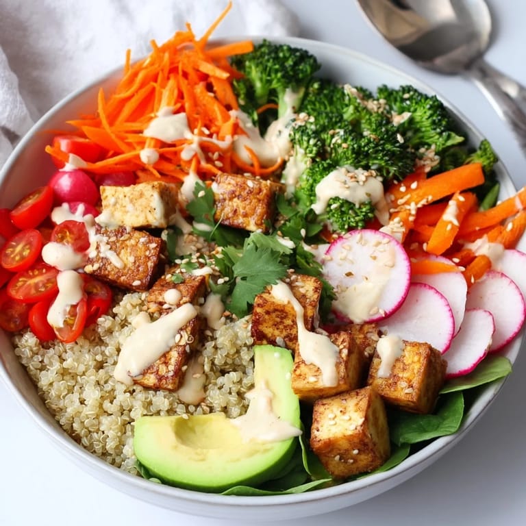 Healthy Buddha Bowl with roasted tofu, steamed broccoli, fresh avocado, cherry tomatoes, and a rich tahini dressing.