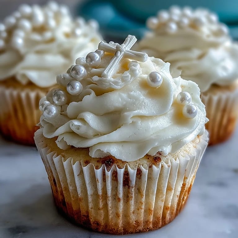 Creamy vanilla mini cupcakes featuring elegant fondant rosary toppers, a beautiful treat for First Communion dessert tables.