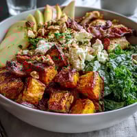 Roasted chicken and caramelized sweet potatoes for the Fall Sweet Potato Harvest Bowl, topped with fresh kale and crumbled goat cheese.