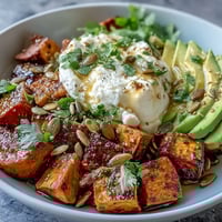 Golden roasted sweet potato cubes with crispy edges, creamy avocado, and cottage cheese in a Hot Honey Sweet Potato Bowl.
