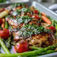 Healthy Easy Sheet Pan Chicken with Spring Veggies sizzling on a colorful tray, tender chicken nestled among crisp asparagus and bright cherry tomatoes.